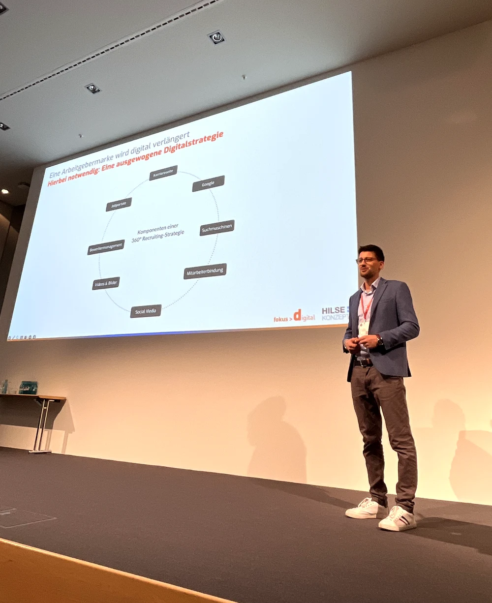 Giovanni Bruno als Speaker auf der Bühne der ALTENPFLEGE-Leitmesse mit seiner 360-Grad-Recruiting-Strategie